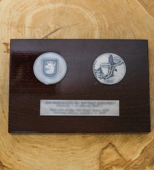 oprawione medale z tabliczką na drewnianej desce